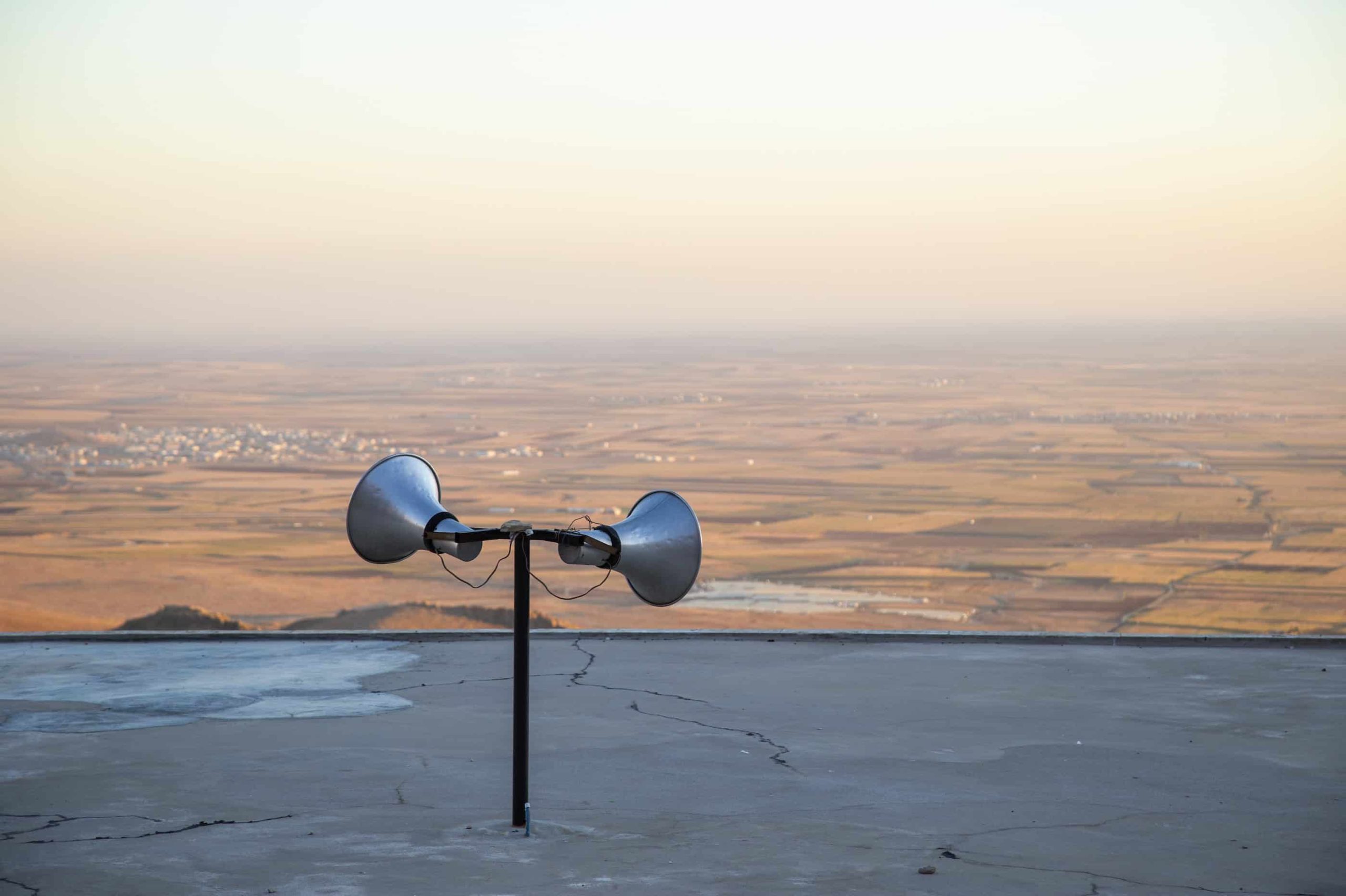 Photo: Ateş Alpar artwork - a photo of loudspeakers placed over a semi-deserted area