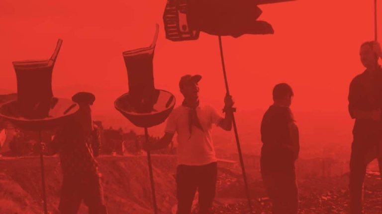 A photo of people performing in public space holding strange props