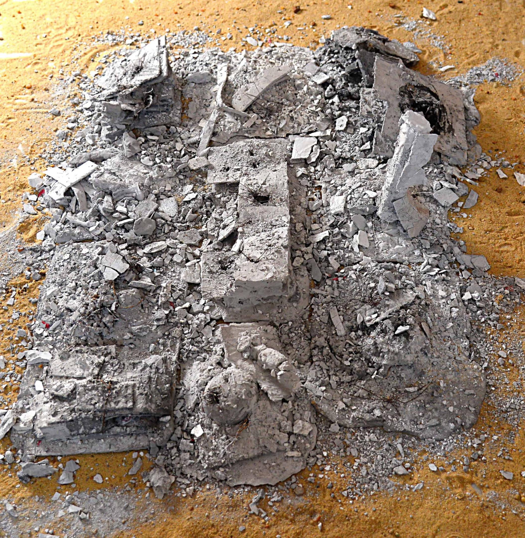 Photo: artwork depicting a pile of rubble on the sand