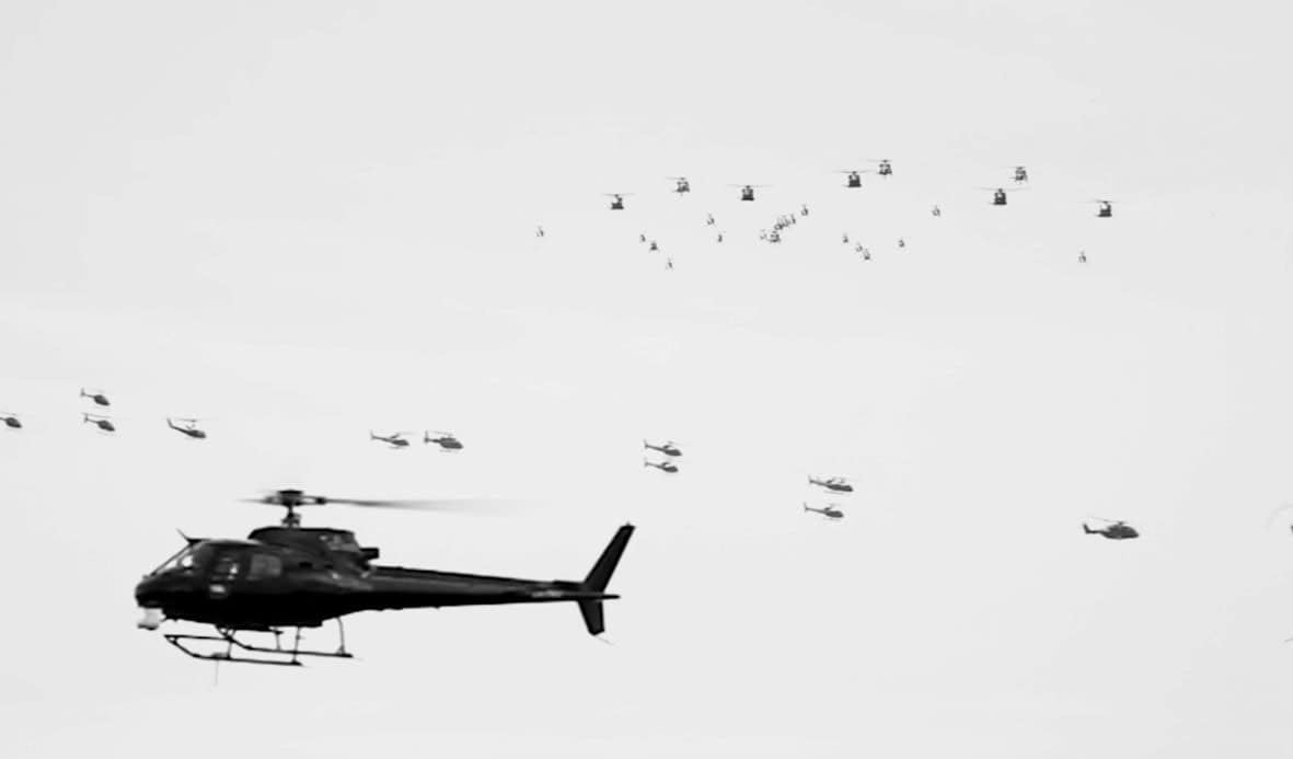 Filmden, uçuş halindeki çok sayıda askeri helikopteri gösteren bir kare.