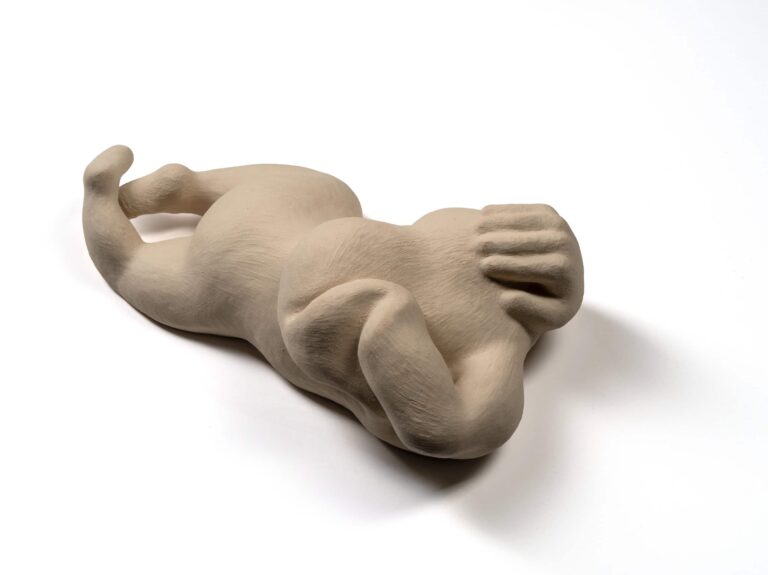 Elleri başını örtmüş, beyaz arka planda yerde yatan stilize insan vücudunu gösteren sanat eseri / kil heykel