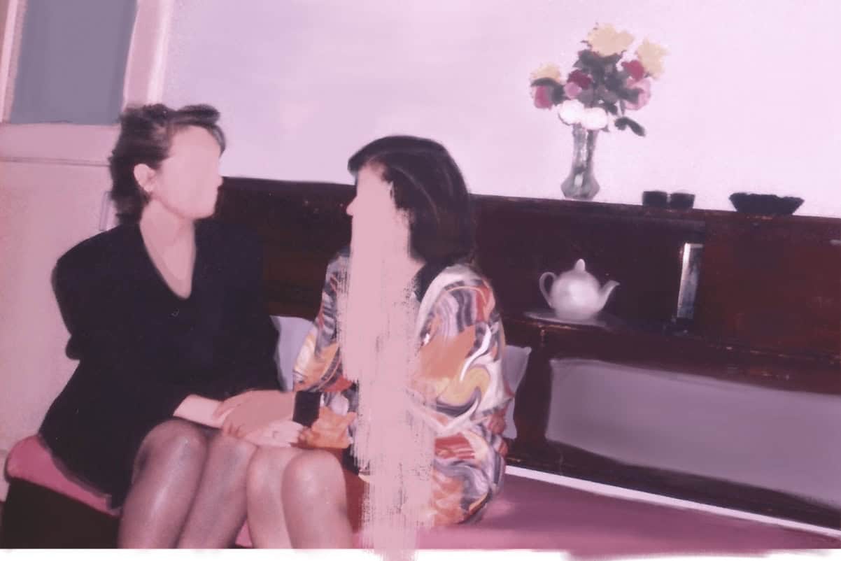 A polaroid photo-like realistic painting depicting two women sitting on a sofa in a domestic background holding hands and turned towards each other with their faces washed out.